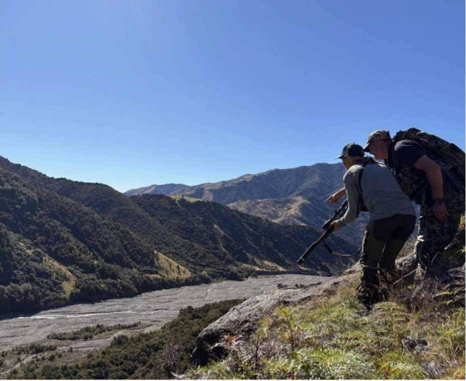 Hunter and guide above a braided river valley