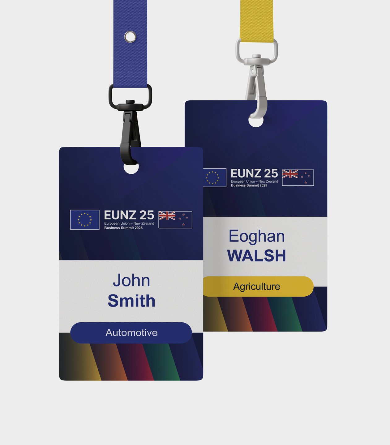 Two conference ID badges hanging from lanyard clips. The badges are for the EUNZ 25 European Union-New Zealand Business Summit 2025.