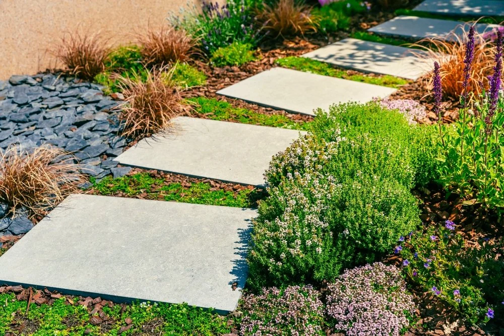 Natural stone walkway with artificial plants and decorative rocks in a xeriscape landscape design in Littleton, Colorado.