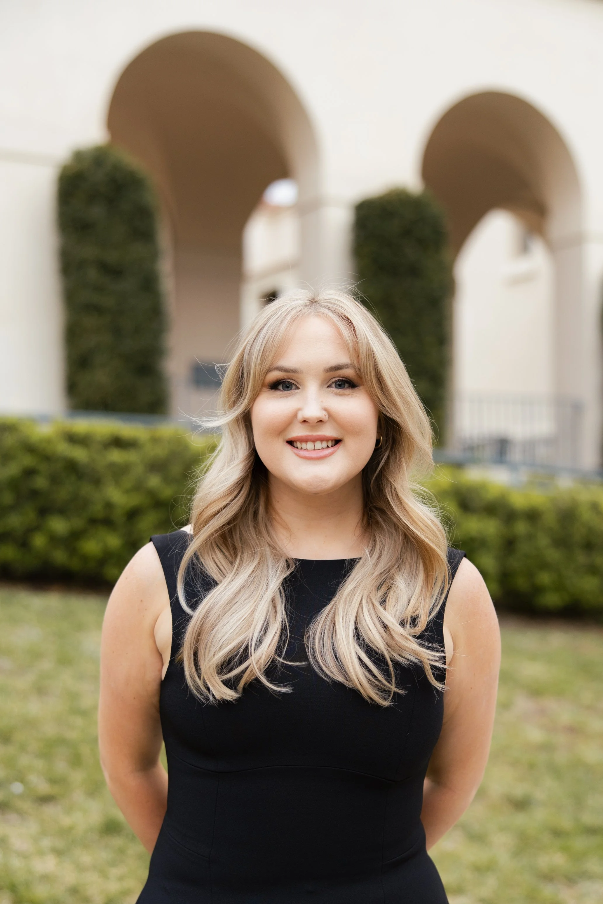 Kayla Hawking, Associate Marriage and Family Therapist, standing outdoors near a professional office building in California.