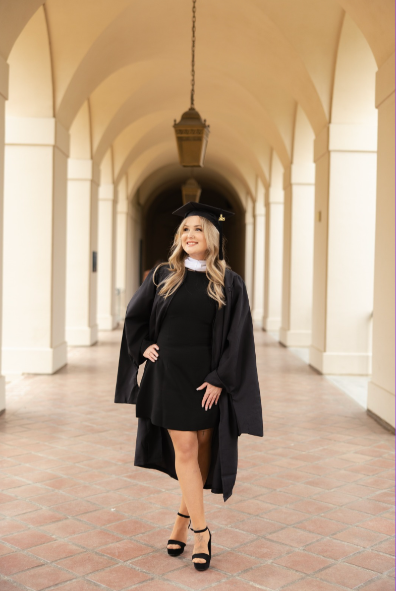 Kayla Hawking graduating with a Master of Arts in Marriage and Family Therapy, standing in a campus archway.