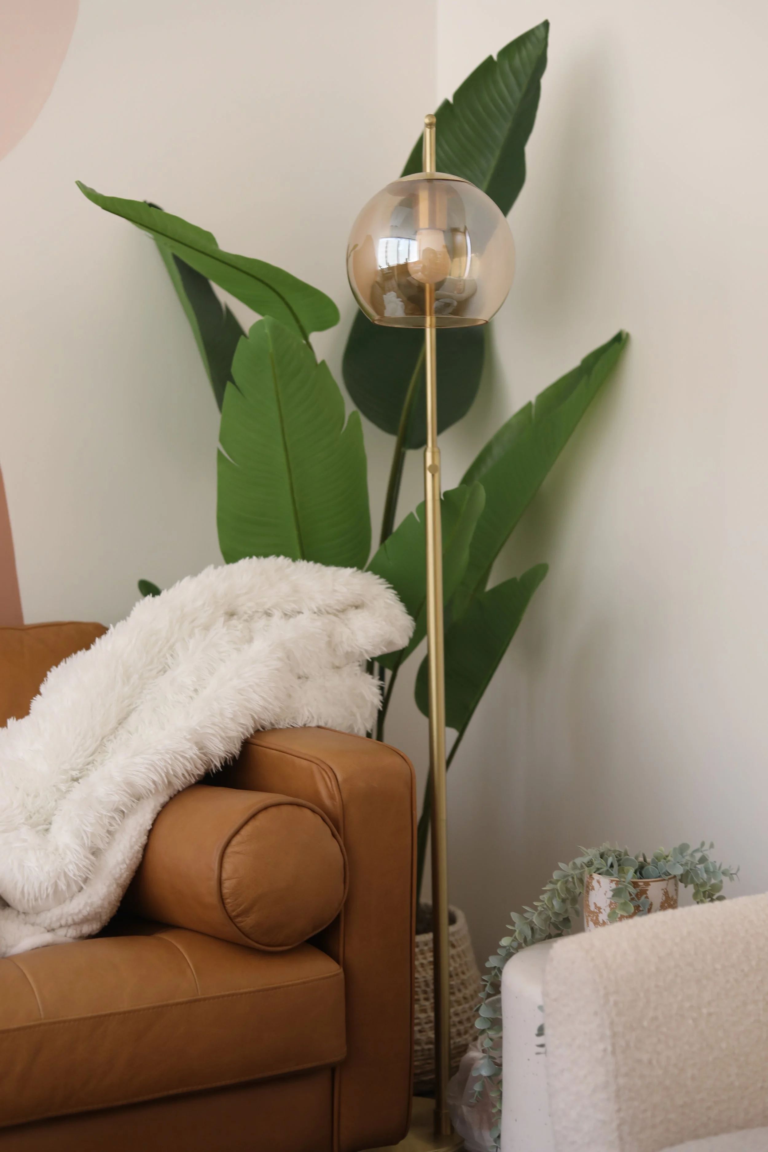 Cozy therapy office seating with leather chair, soft blanket, and plants in an Irvine therapy office.