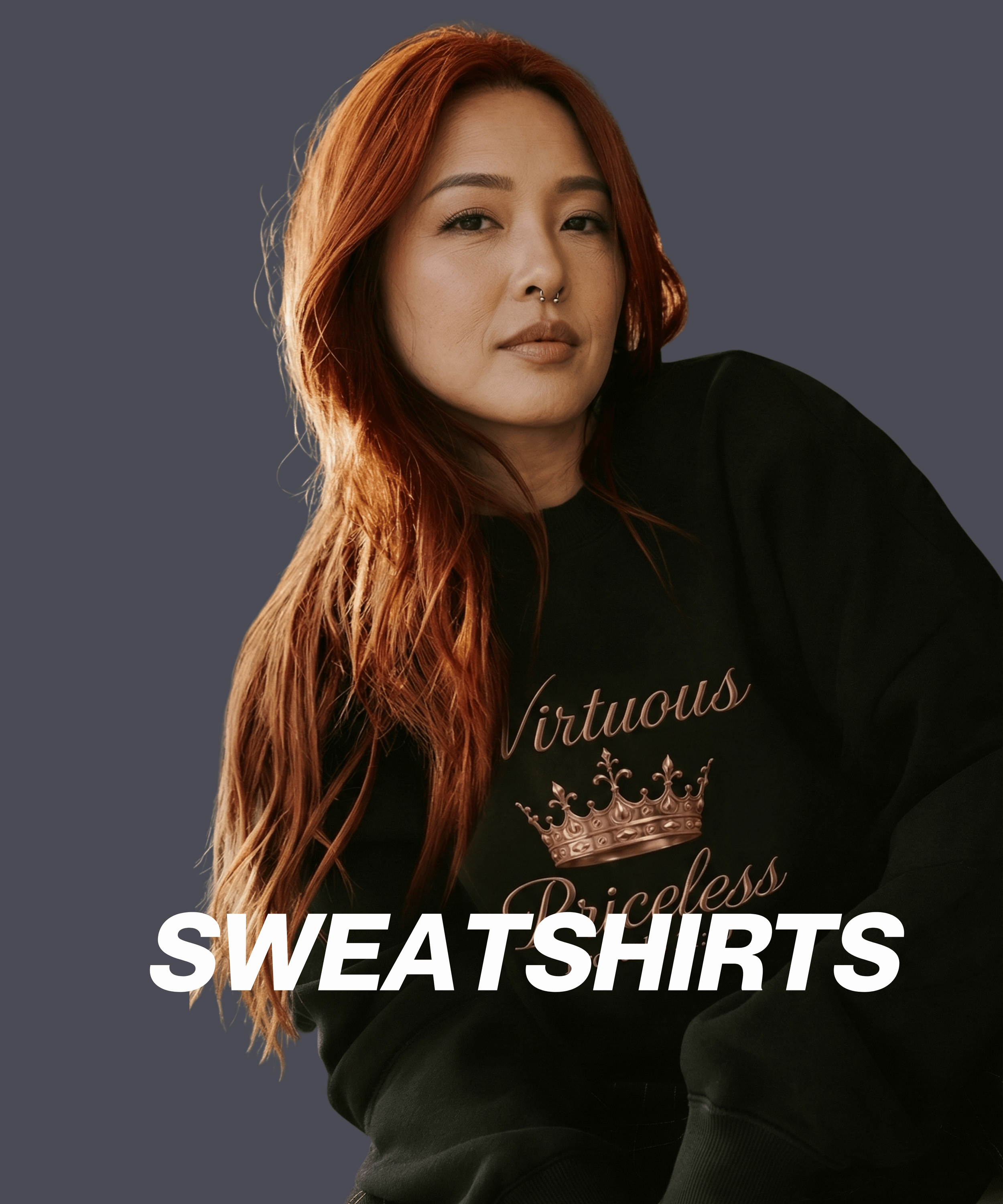 Portrait of a woman with long red hair wearing a black sweatshirt with a crown design and the words 'Virtuous Priceless'.
