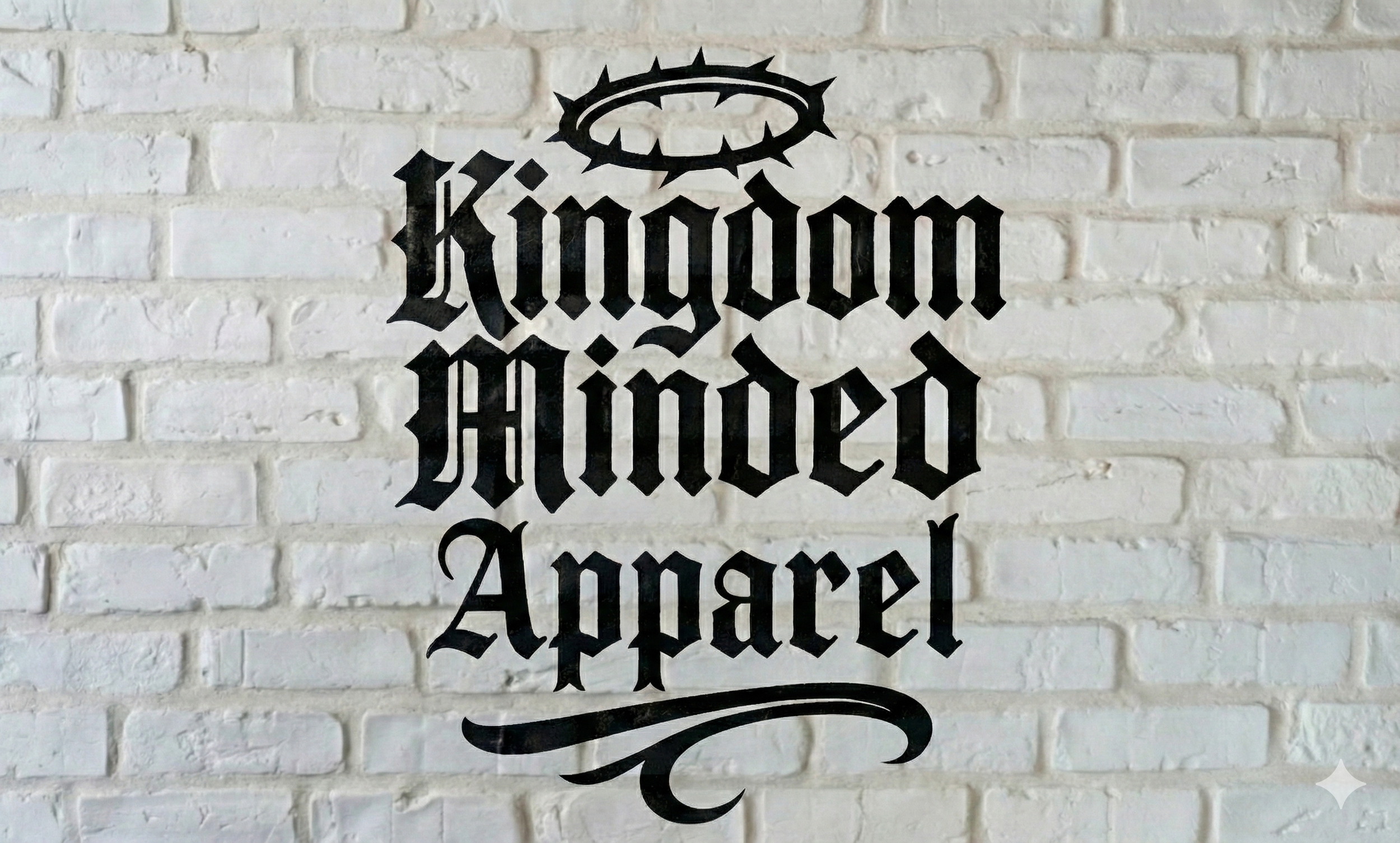 Black gothic-style text on a white brick wall that reads "Kingdom Haunted Apparel" with a crown and halo above the word "Kingdom".