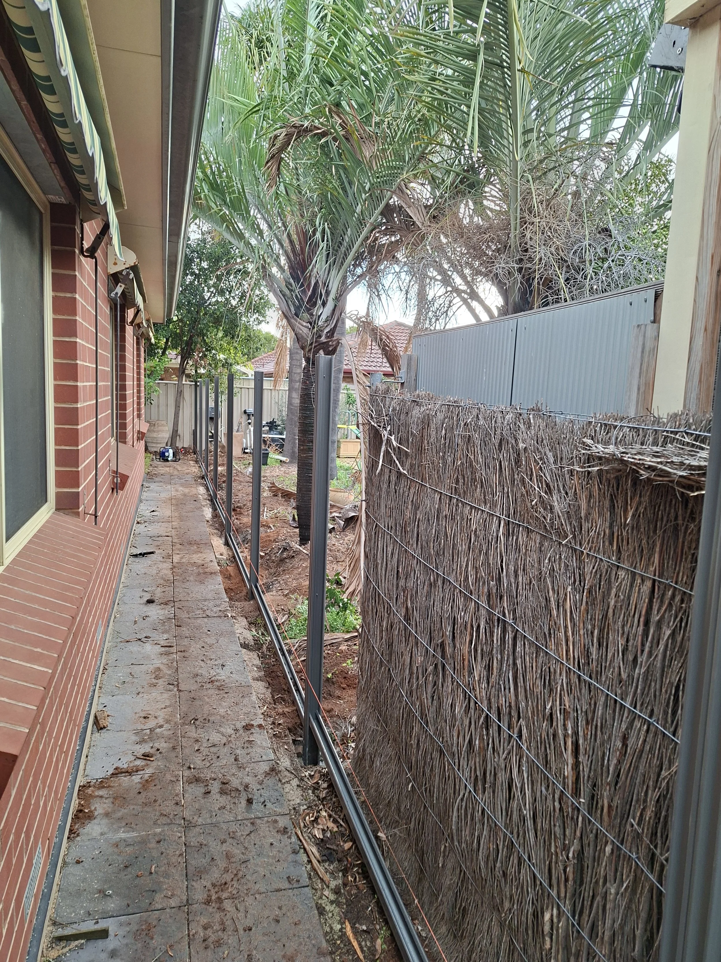 Removal of brush fence panels and installation of new fence posts