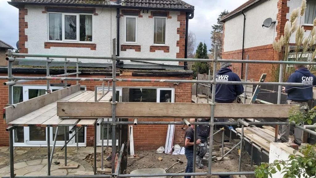 Builders working on an extension using scaffolding