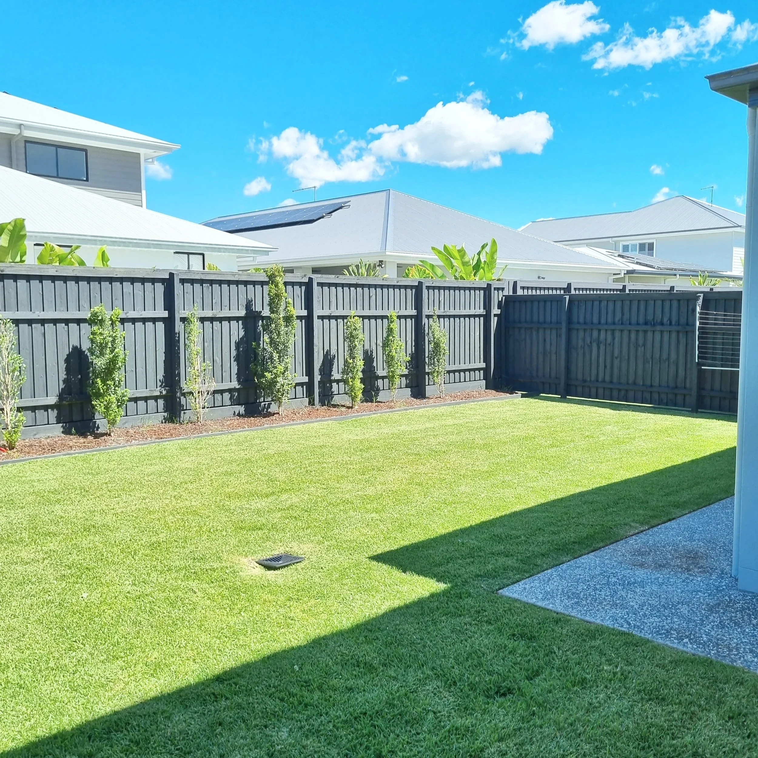 Wide backyard with freshly mowed lawn and neat edges – North Lakes lawn mowing service.