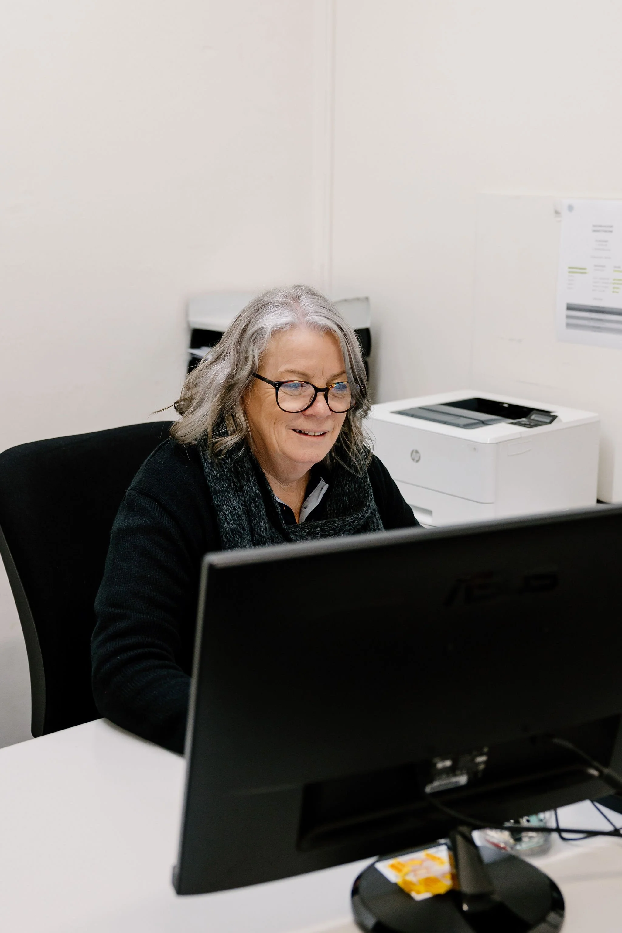Jo, working at a computer in the office.