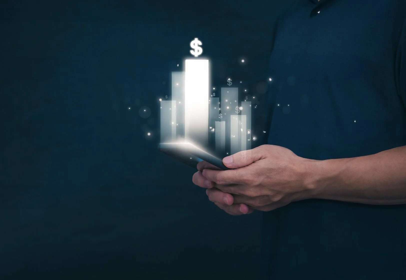 Person holding a tablet computer with a digital graph showing increasing bar heights and dollar signs, representing financial growth or success.