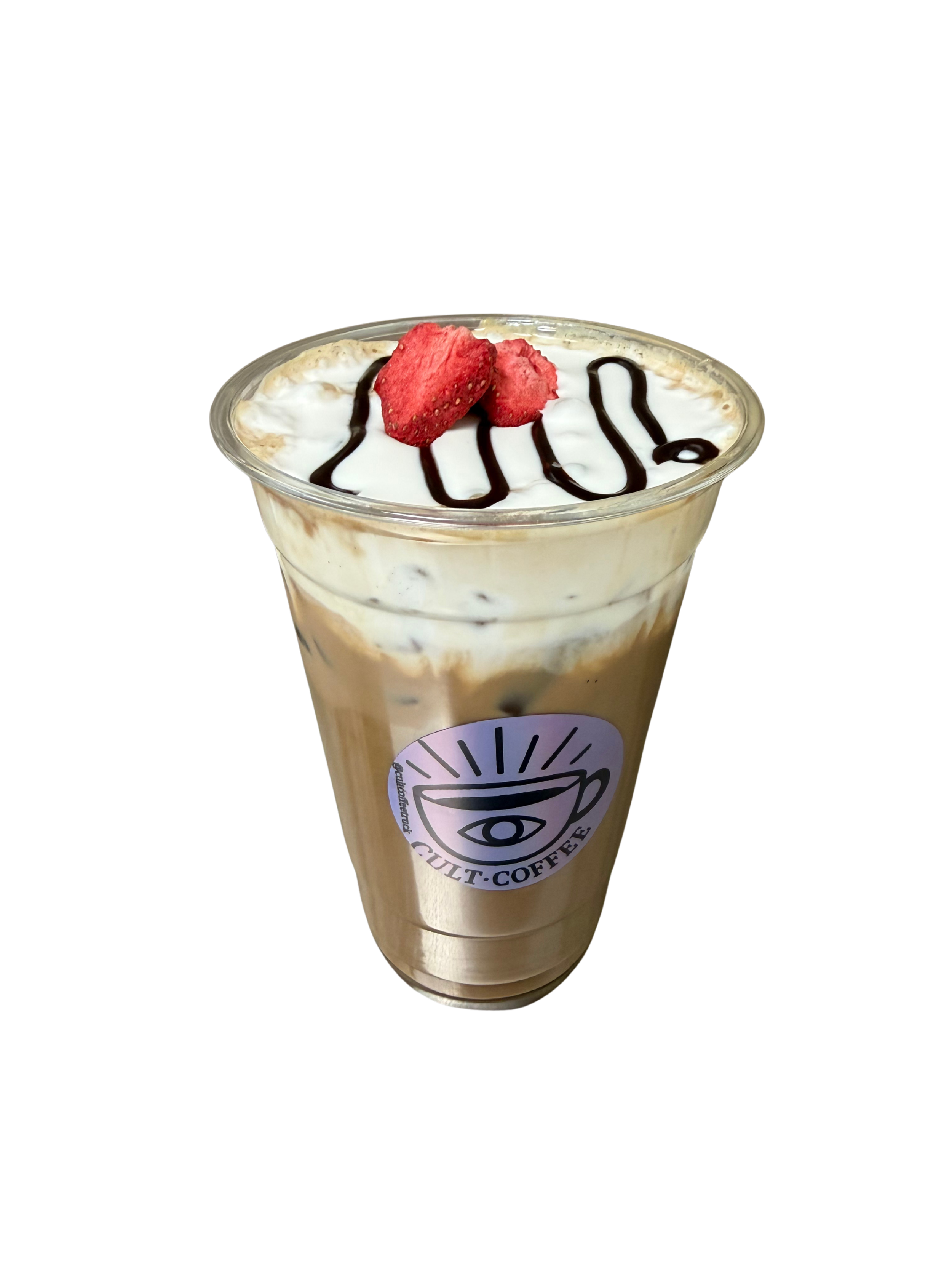 A tall glass of iced coffee with whipped cream, garnished with sliced strawberries and chocolate drizzle, featuring a logo with an eye inside a coffee cup.