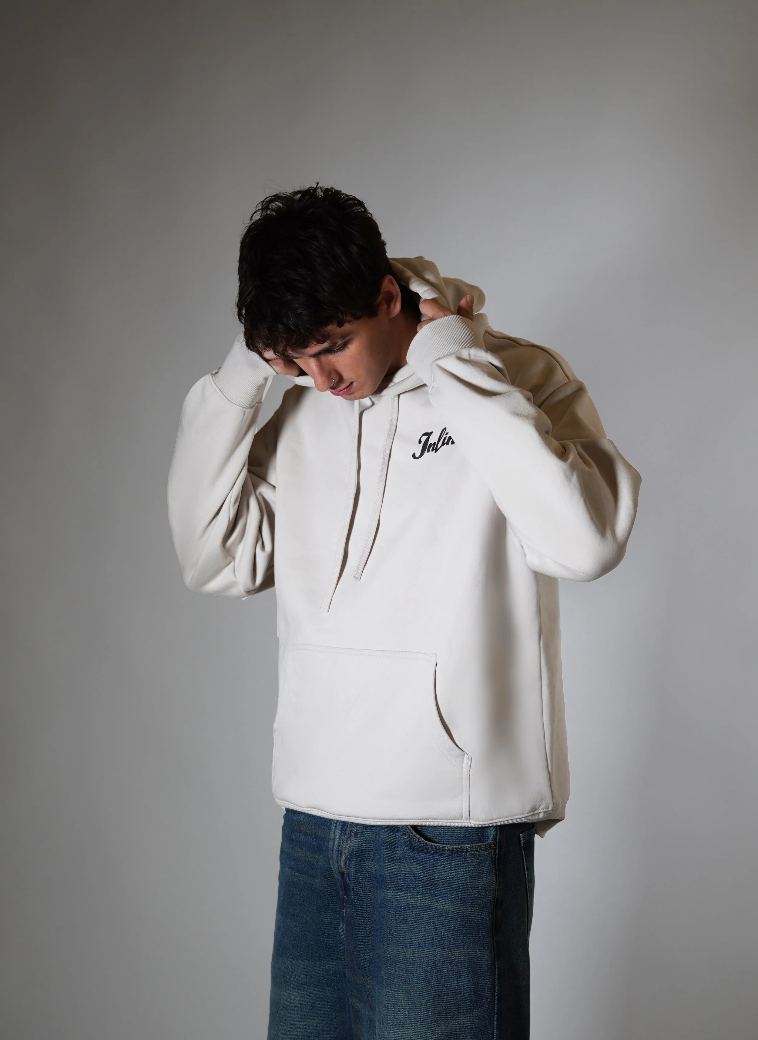 Young man showcasing Inline Clothing luxury streetwear hoodie, inspired by automotive culture and timeless design.