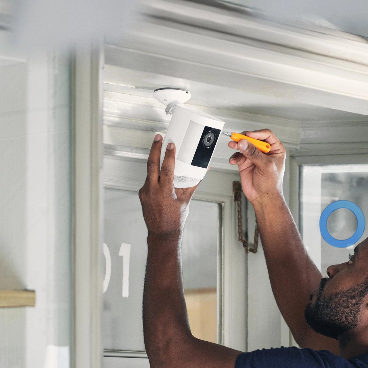 Person installing or repairing a security camera near the ceiling.