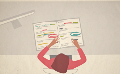 Top-down view of a woman with brown hair sitting at a desk, organizing weekly planner pages with colorful tabs for each day.