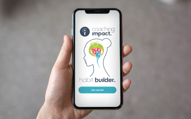 A hand holding a smartphone displaying the Coaching Impact Habit Builder app screen with a logo and a 'Get Started' button.