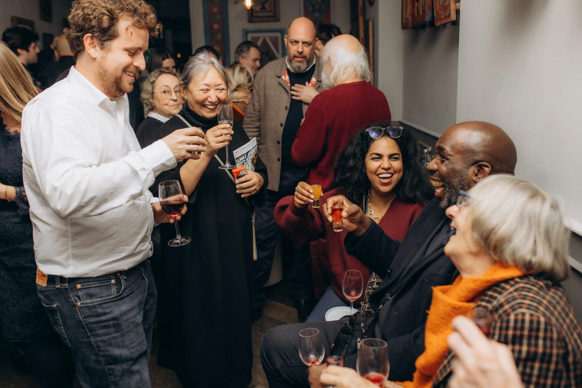 Guests are drinking and smiling at a busy evening reception