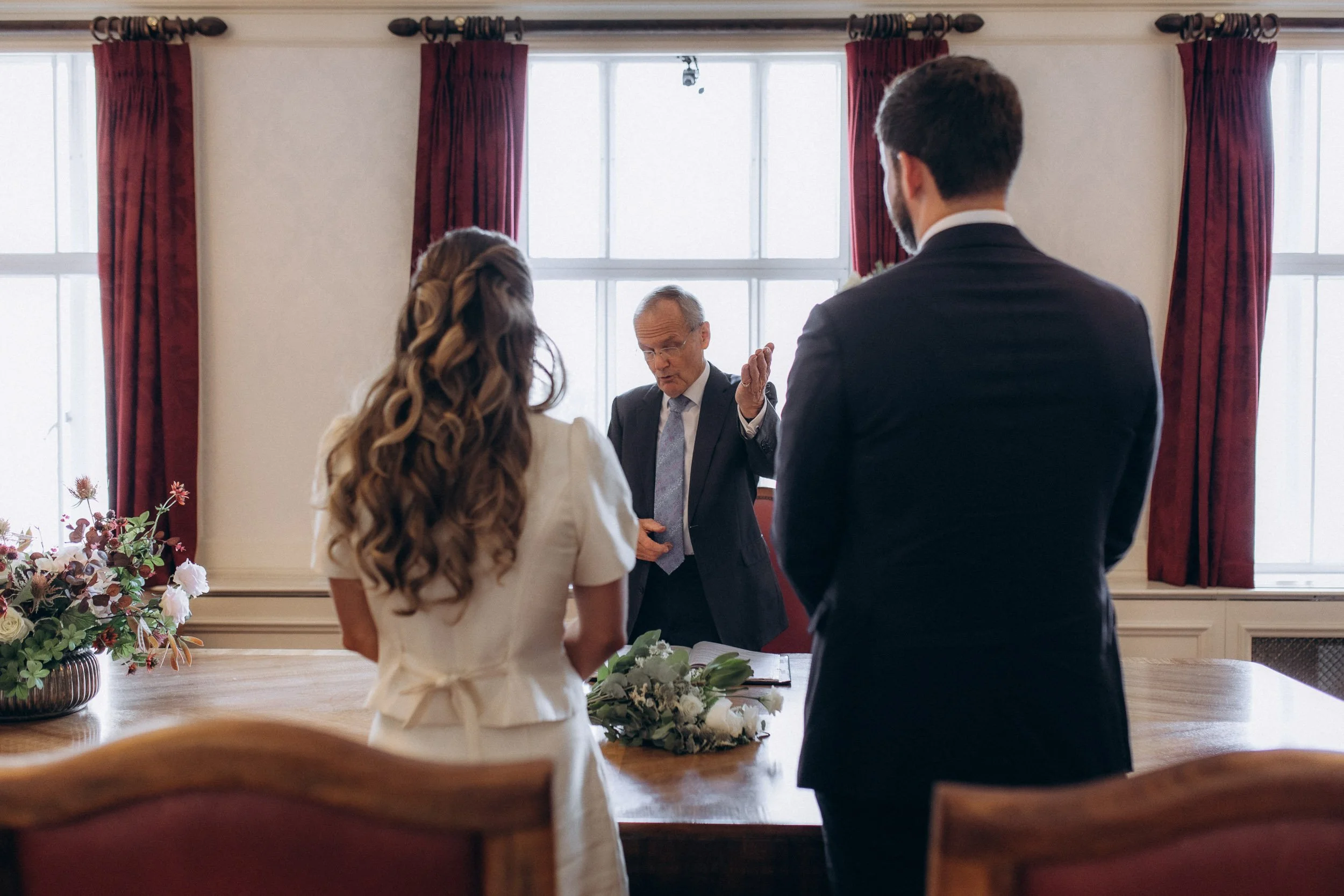  Couple standing at the art deco table during their ceremony in the Victoria Room, Wandsworth Town Hall 
