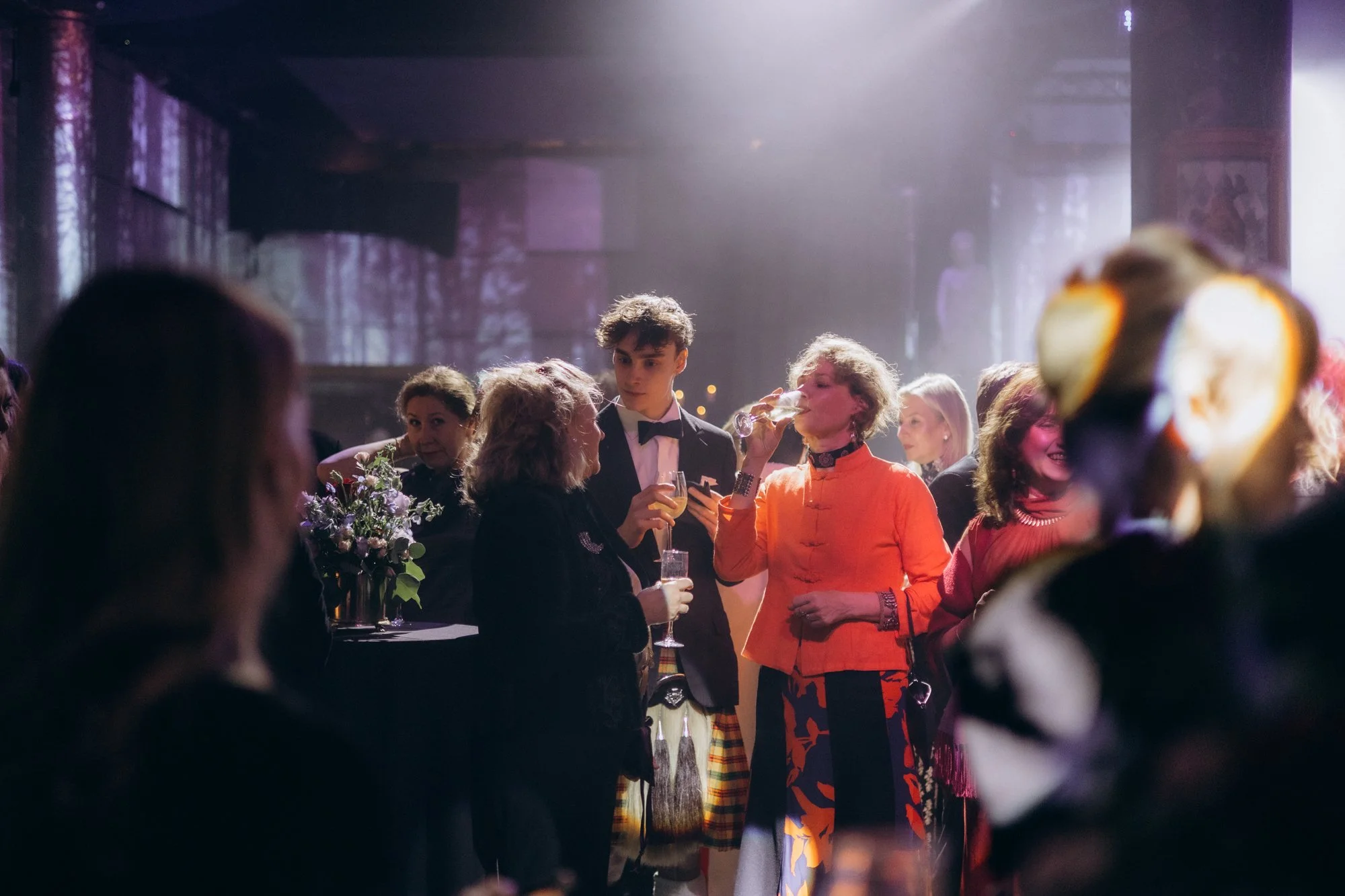 Guests raising glasses in a toast at an evening celebration