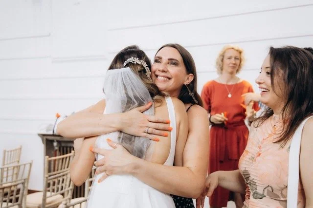 Bride embracing a guest warmly after the ceremony in Fulham library ceremony