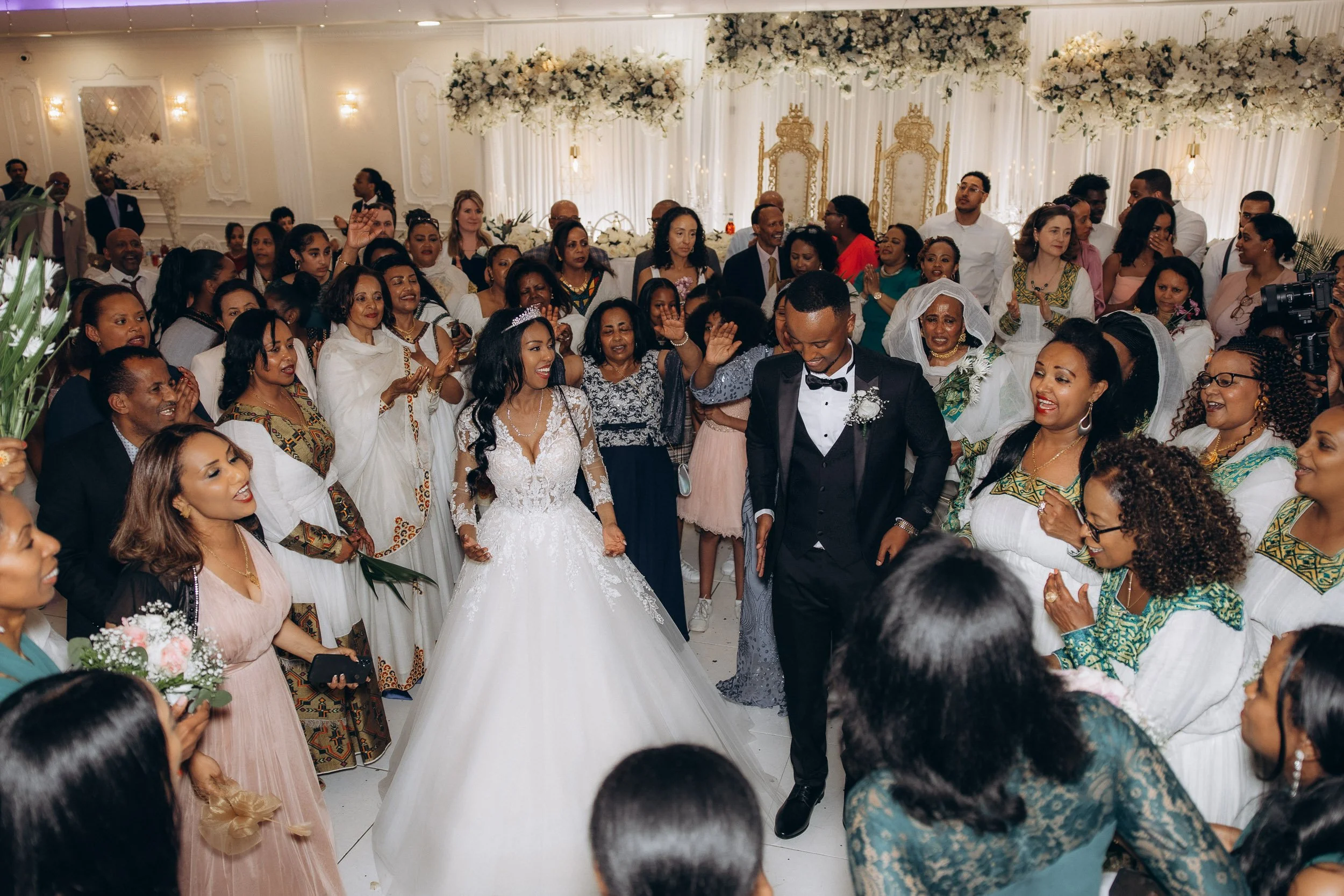 High-energy candid shot of the bride and groom dancing surrounded by cheering guests at a vibrant London wedding reception.