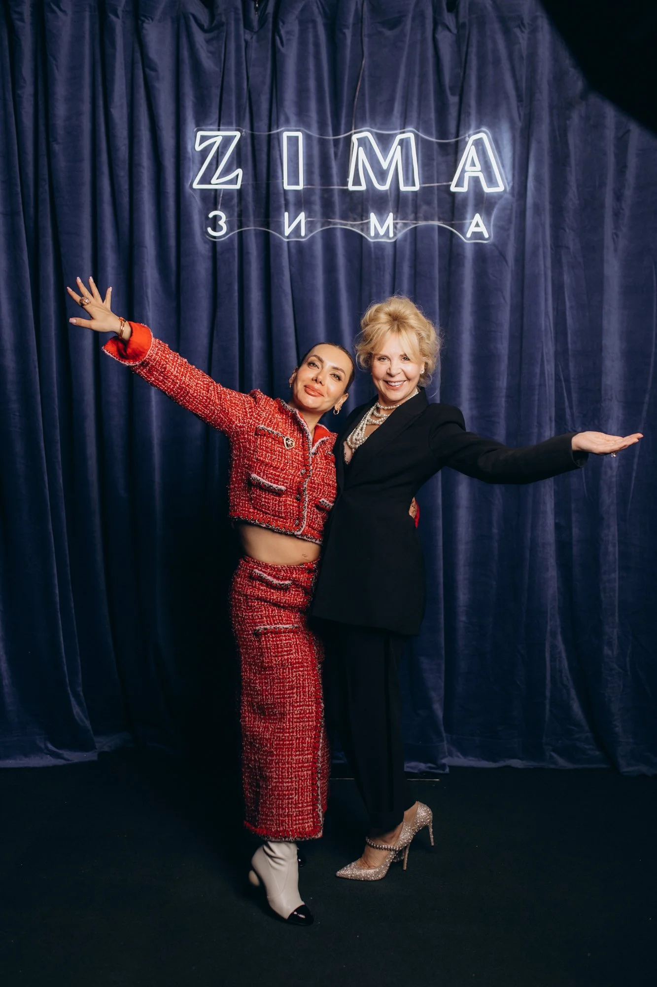 Two guests posing at a branded backdrop at a London awards evening