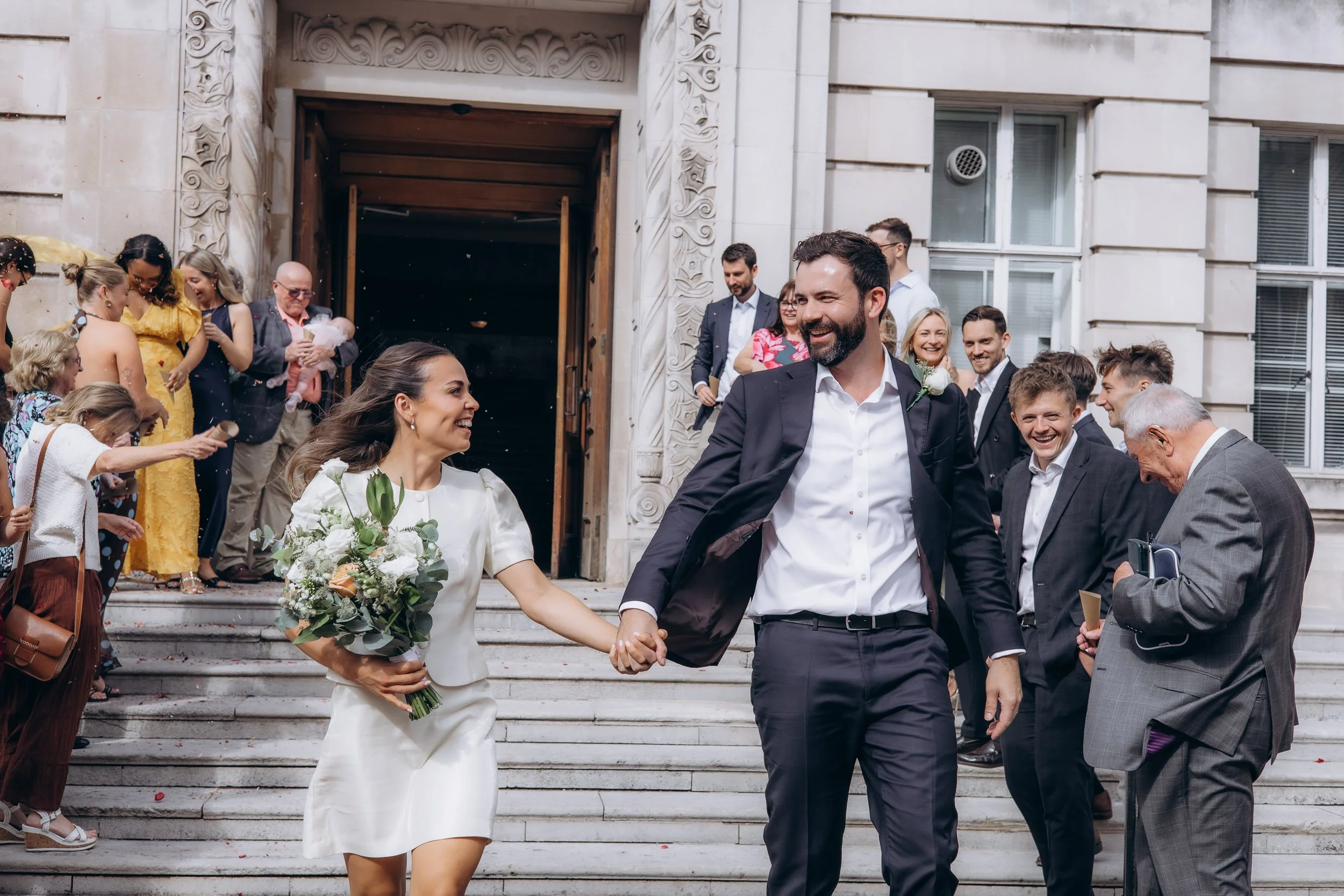 Joyful confetti exit on the front steps of Wandsworth Town Hall after a London register office wedding