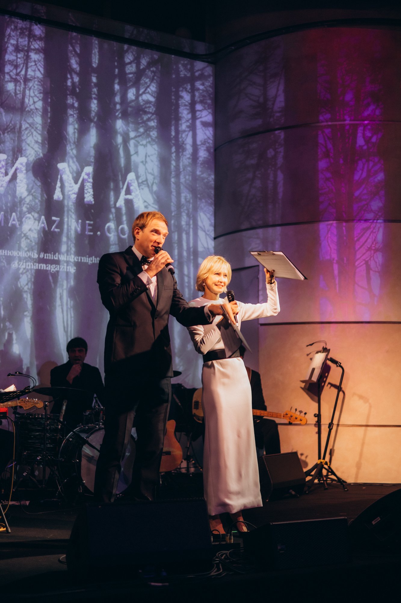 Host and singer performing on stage at a gala dinner in London