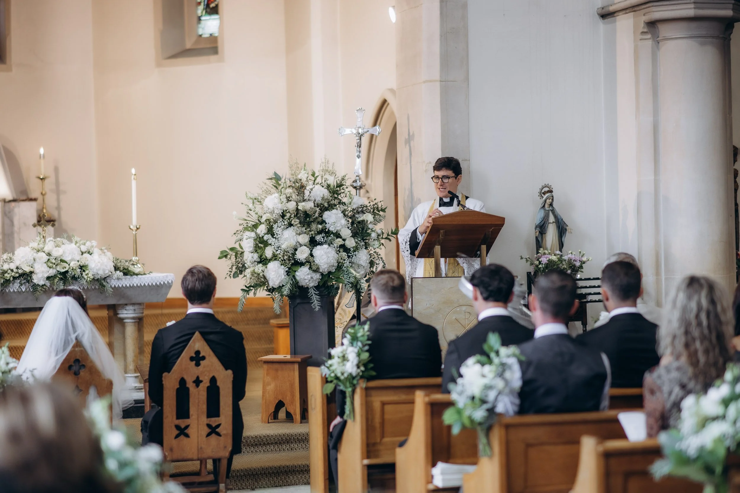 Documentary-style capture of a wedding service in progress, focusing on the honest emotions of the guests and couple.