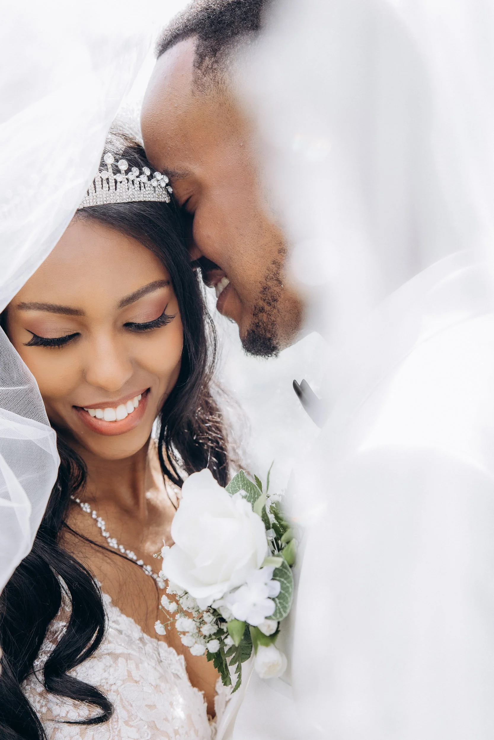 Soft, intimate portrait of a bride and groom sharing a quiet moment under the bridal veil; luxury wedding photography style by Lusy Klintsova.