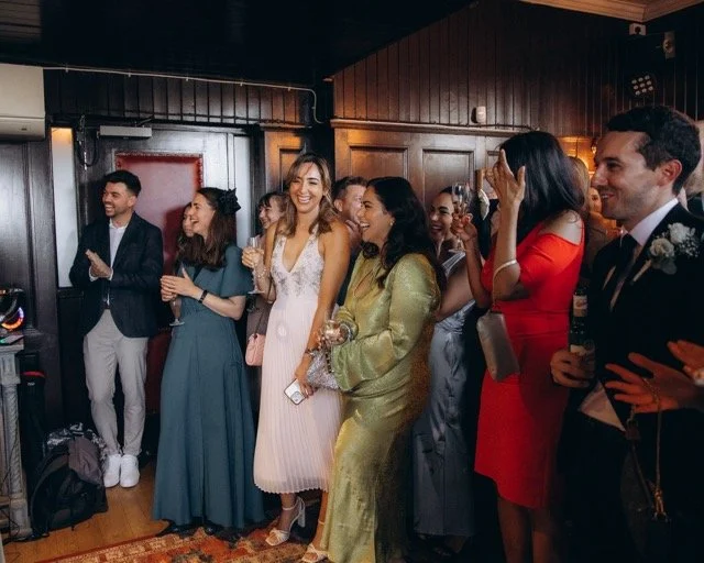 Group of guests laughing and dancing together in a lively reception room at The Old Ship pub