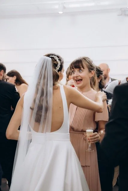  Bride laughing with a guest during her wedding reception — unposed candid moment photographed by London documentary wedding photographer Lusy Klintsova 