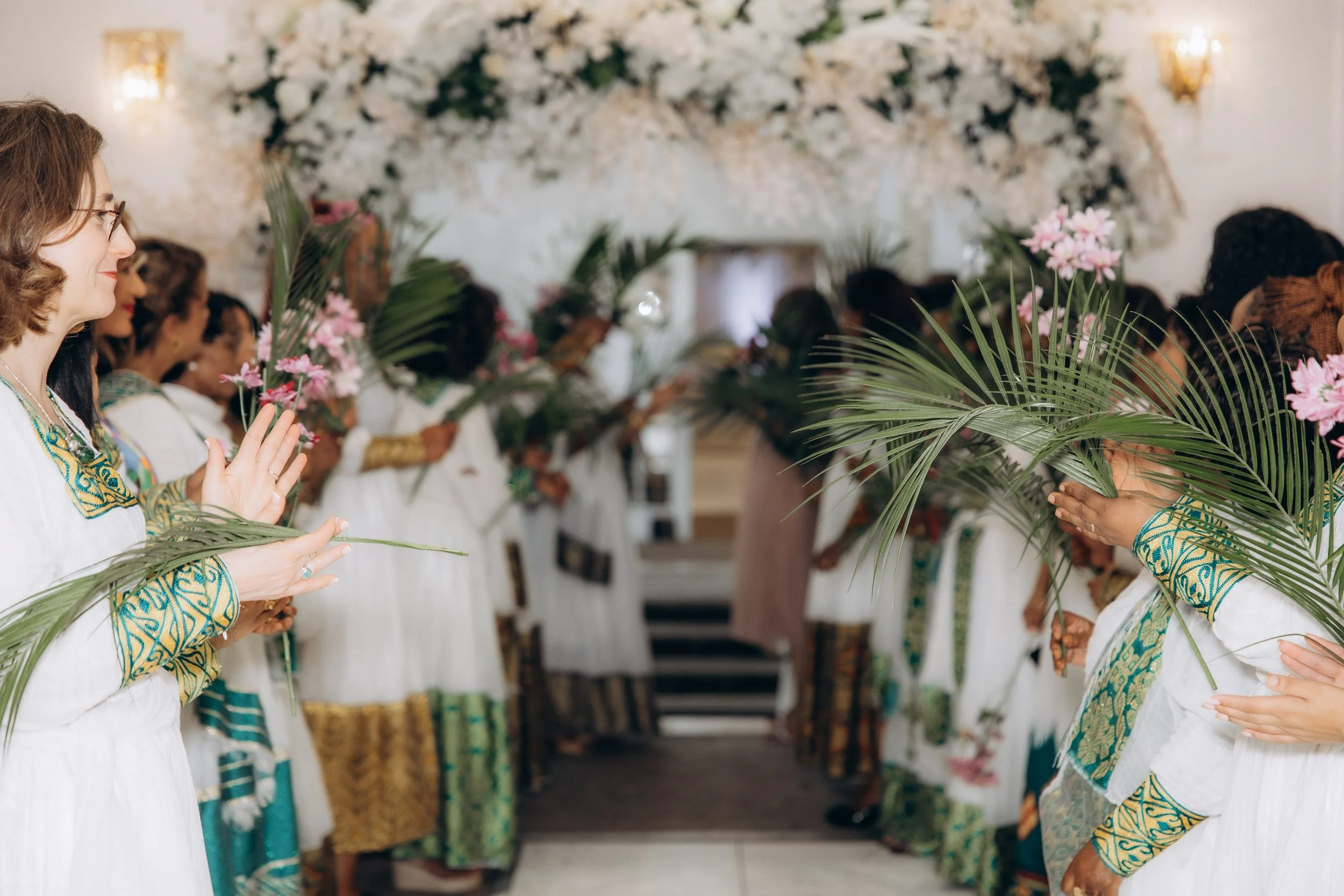 Documentary shot of guests in traditional ceremonial attire lining the entrance for the bride and groom’s reception arrival in London.