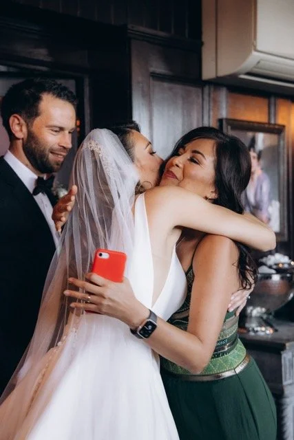 the bride embracing and kissing the friend on the cheek during the ceremony