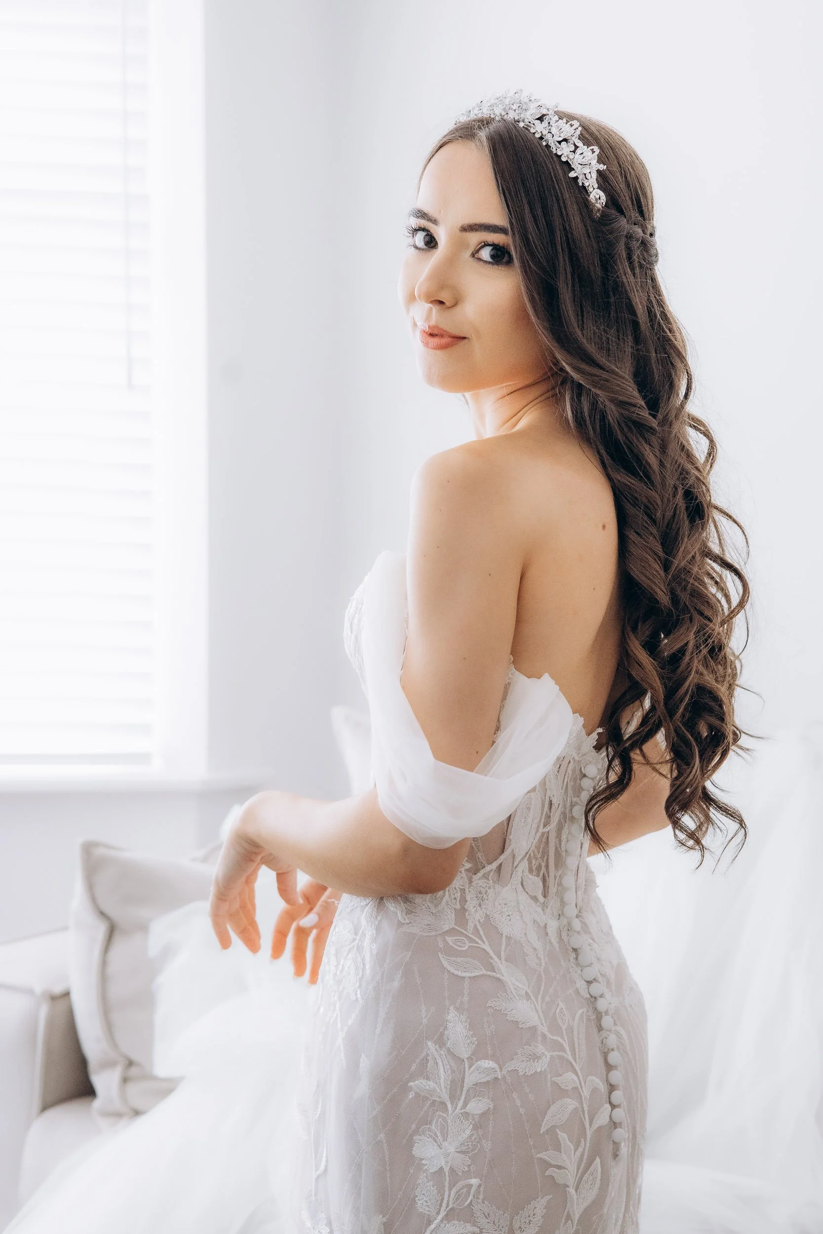 Editorial bridal portrait of a bride in a modern lace wedding dress with soft curls, captured in a bright London setting by Lusy Klintsova.