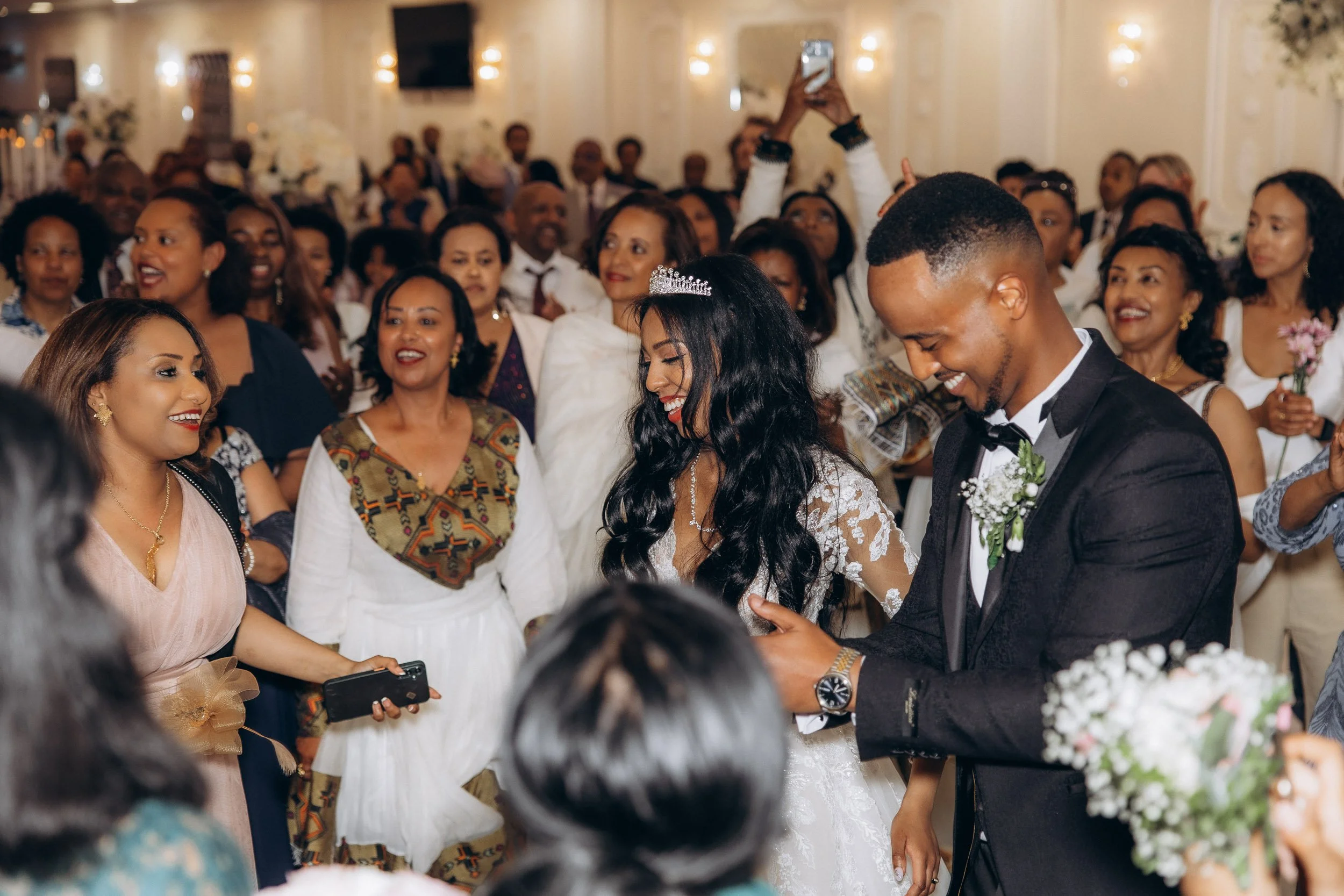 High-energy candid shot of the bride and groom dancing surrounded by cheering guests at a vibrant London wedding reception.