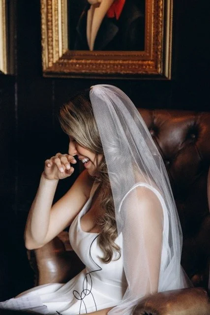 Bride in veil with hands clasped, bowing her head in a quiet, emotional moment at The Old Ship
