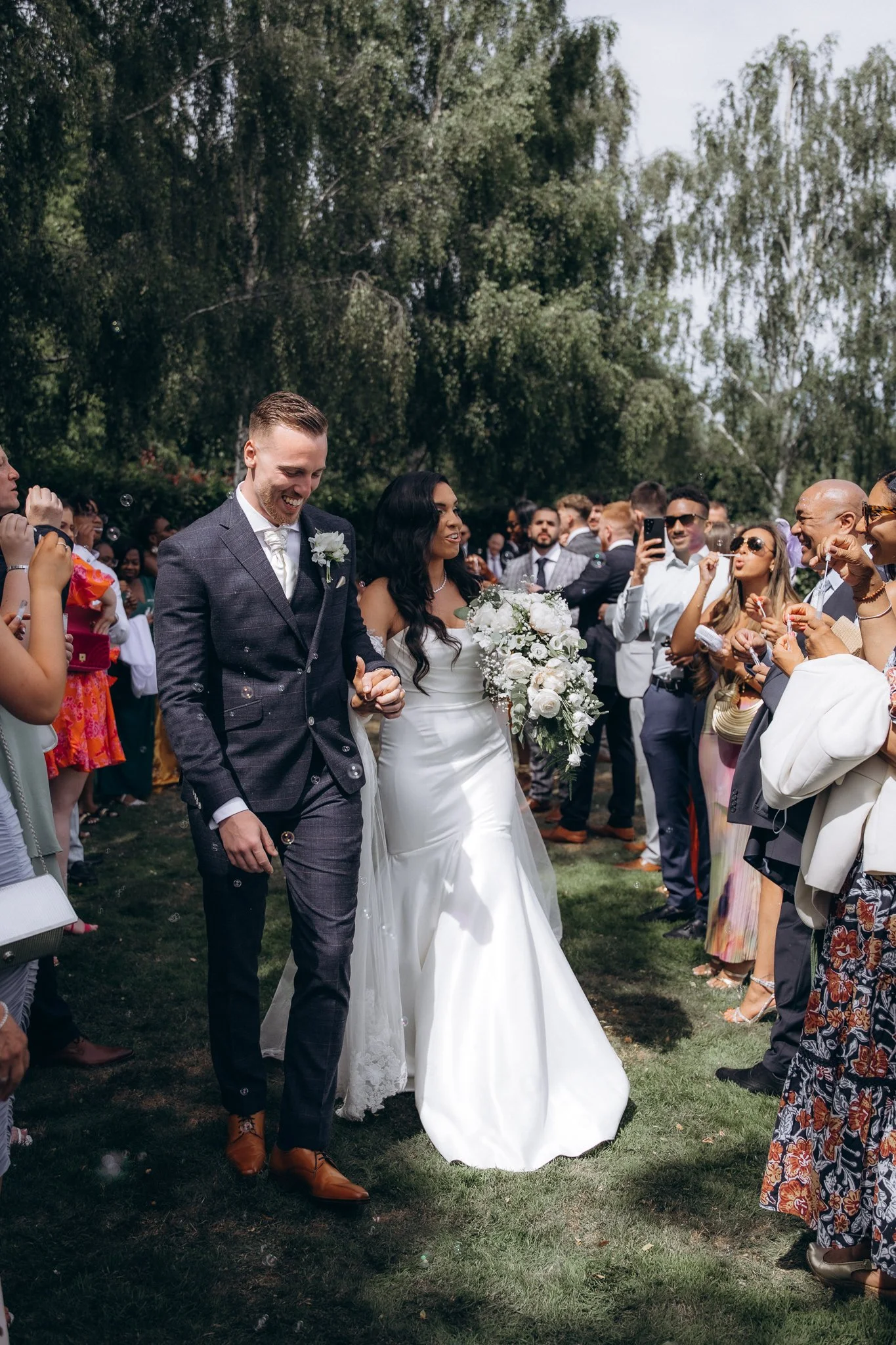 Bride and groom walking down the aisle as guests applaud