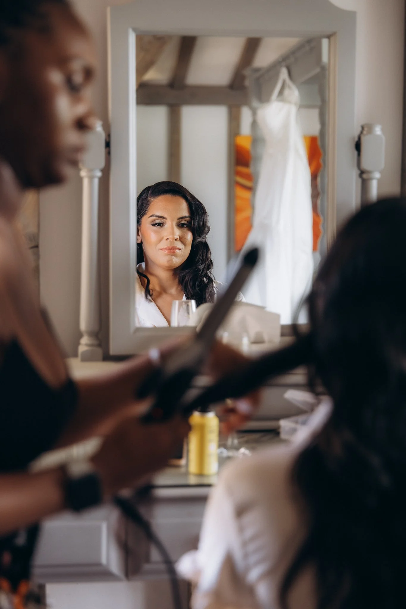 Bride looking into a mirror with soft curled hair, reflection close-up