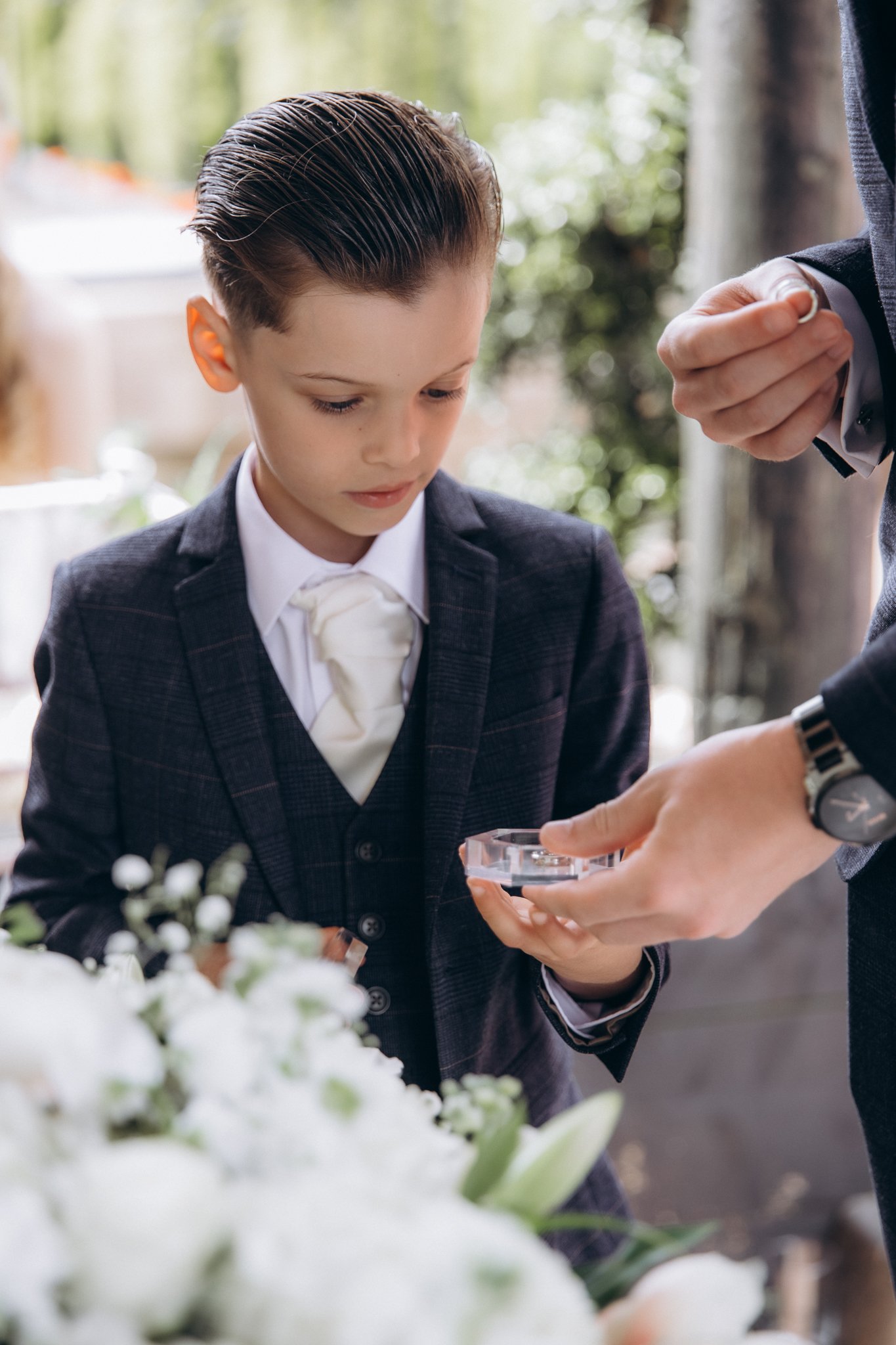 Young page boy having his cufflinks fastened before the ceremony