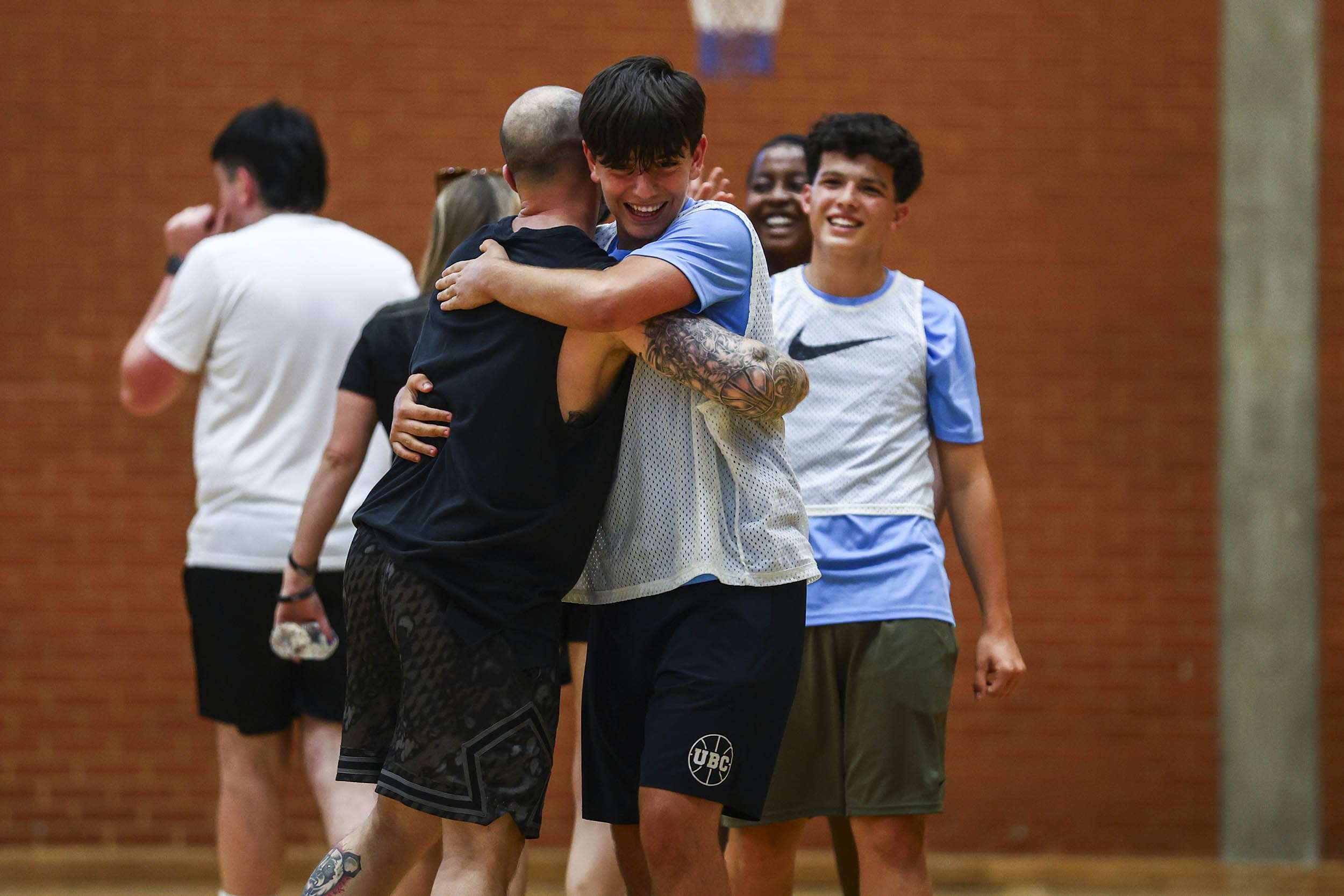 Jugador de baloncesto y entrenador abrazándose