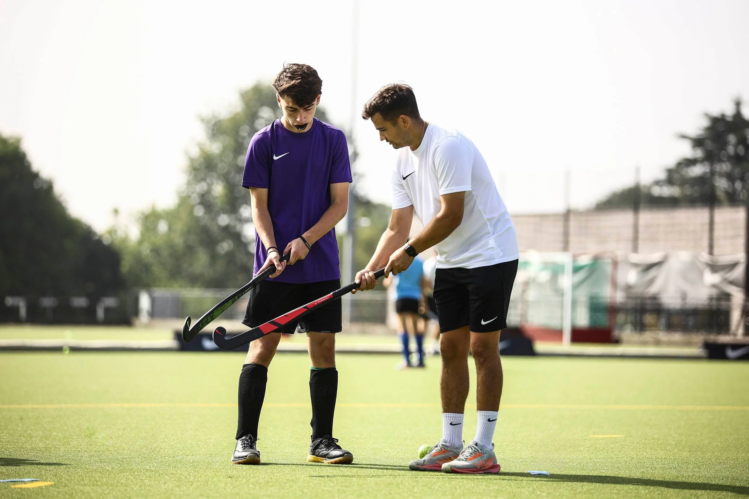 Hockey coach correcting player's grip