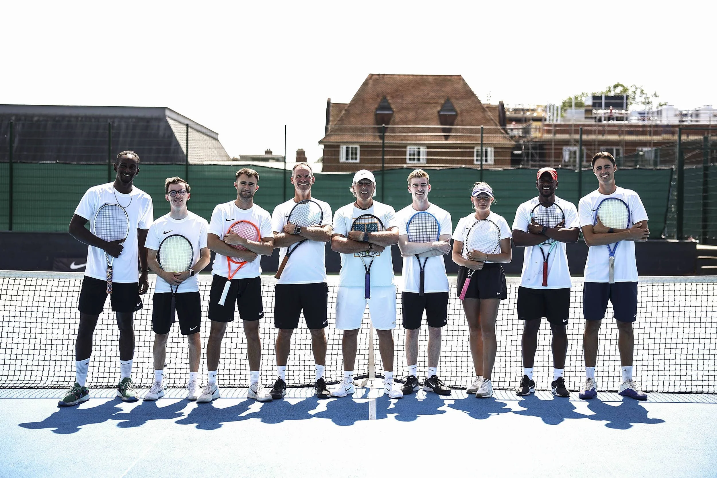 Tennis coaching team holding rackets on Nike Tennis Camp