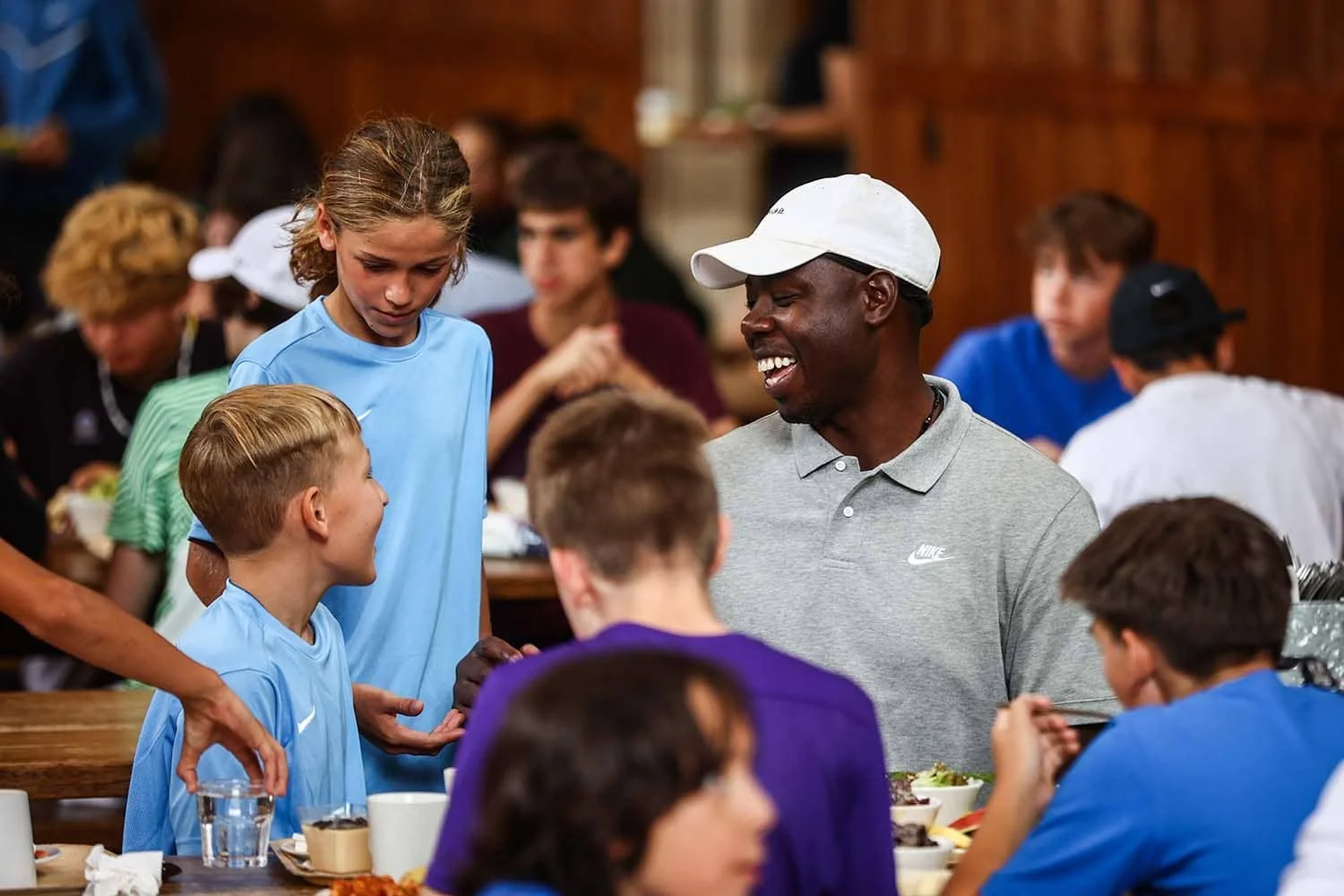 Eric Boateng spricht beim Mittagessen mit Kindern