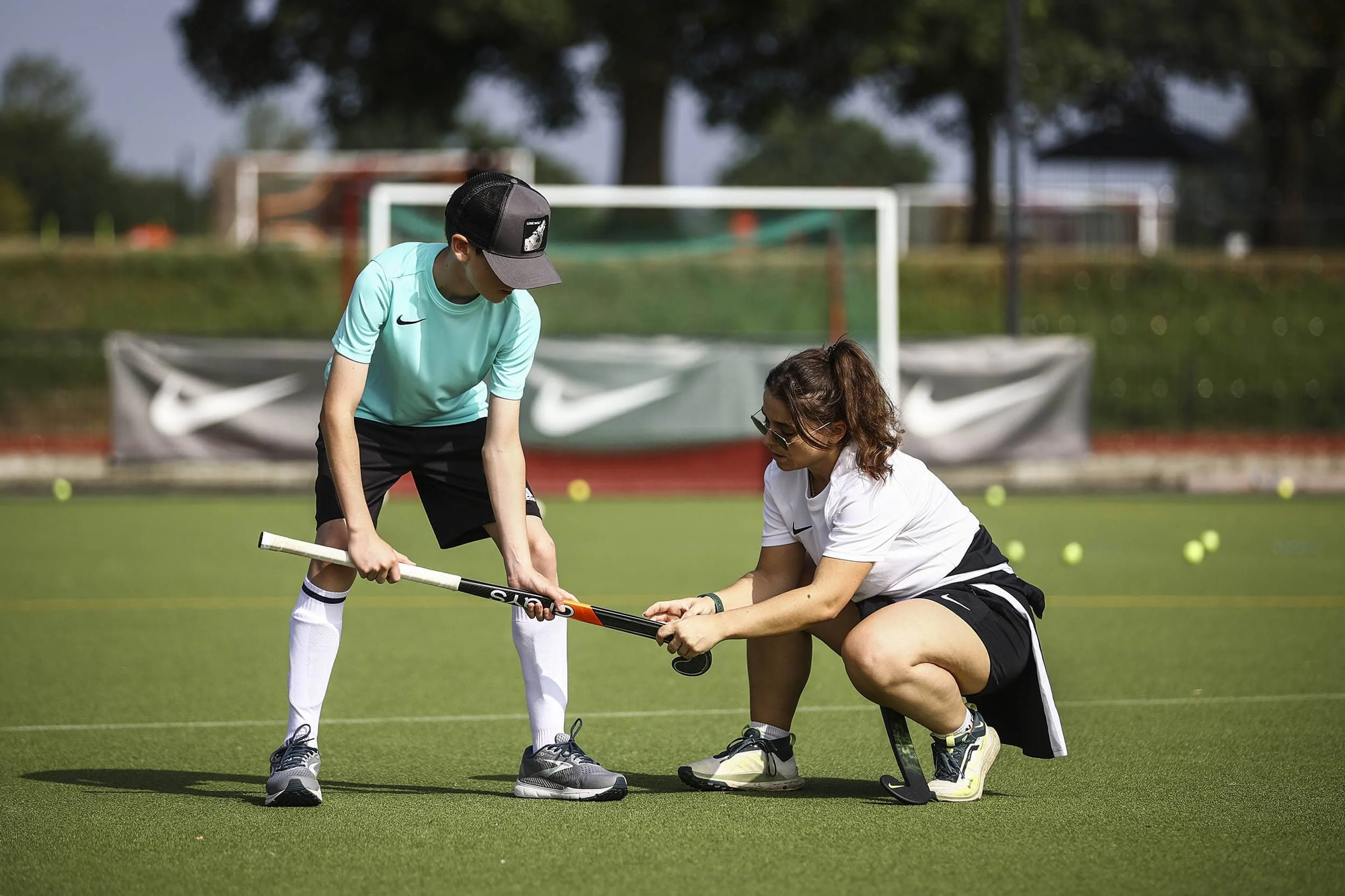 boy learning hockey with hockey coach