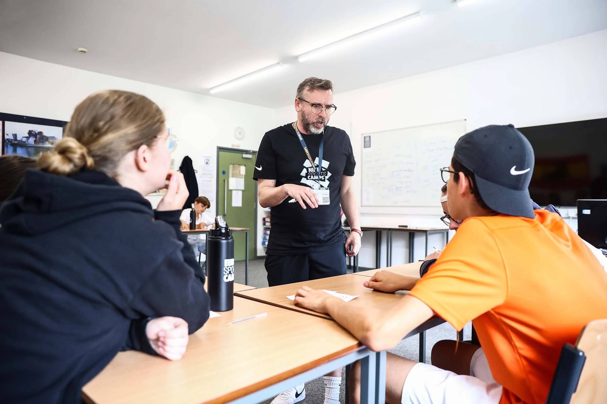 English teacher speaking to students in the classroom on Nike summer camp