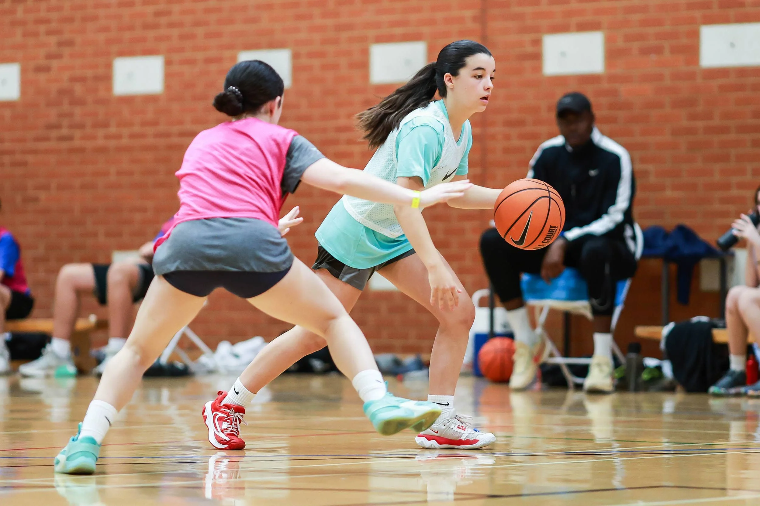 Dos chicas jugando al baloncesto en el Nike Sports Camp en Inglaterra.
