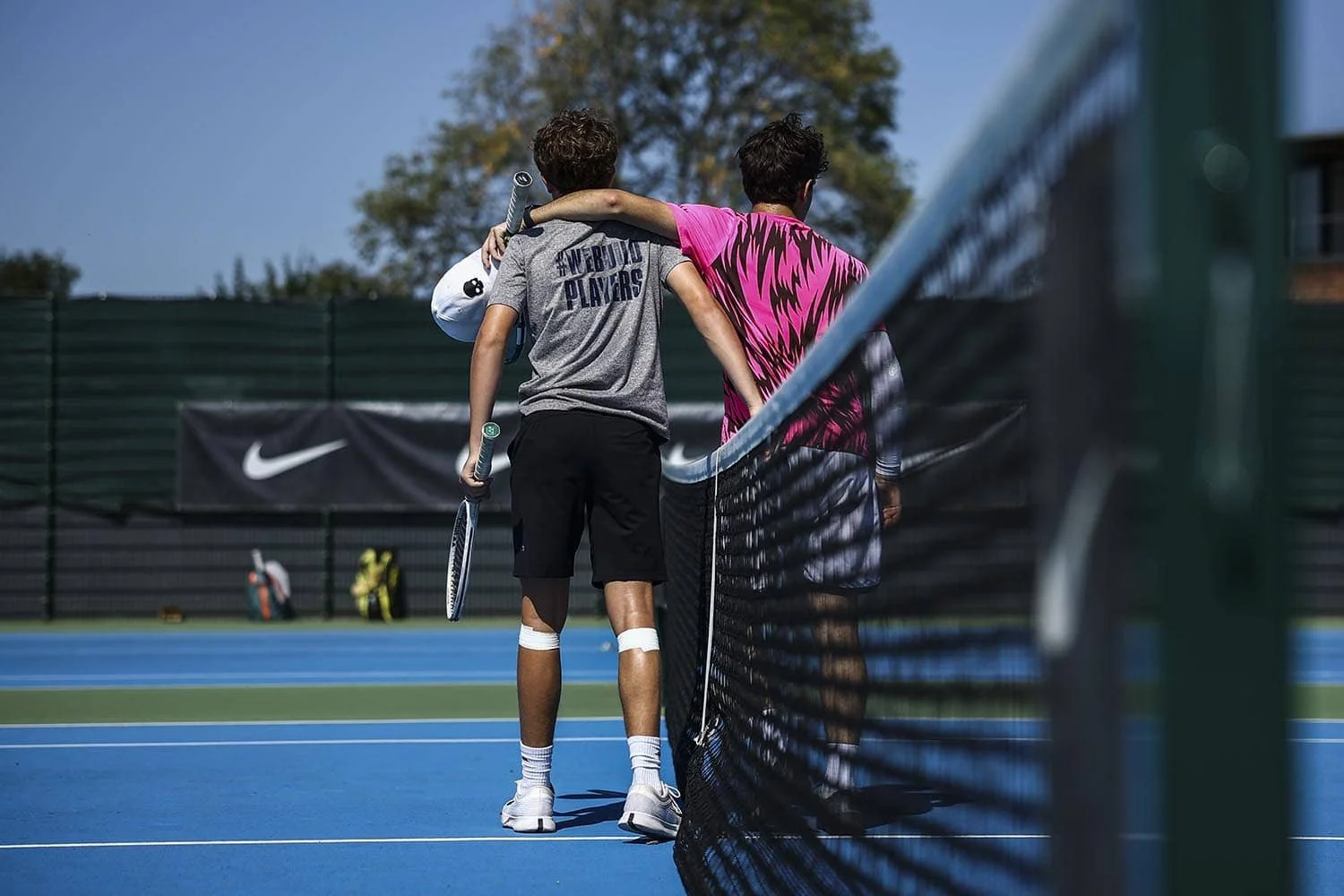 boys embracing on the tennis court