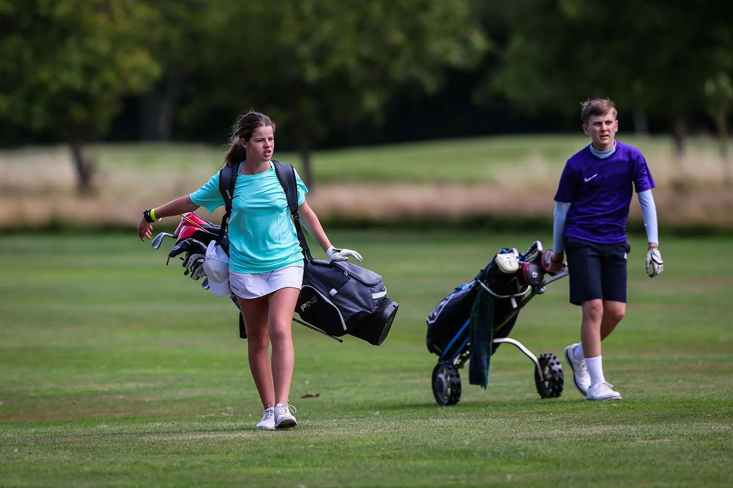 niño y niña en el campo de golf