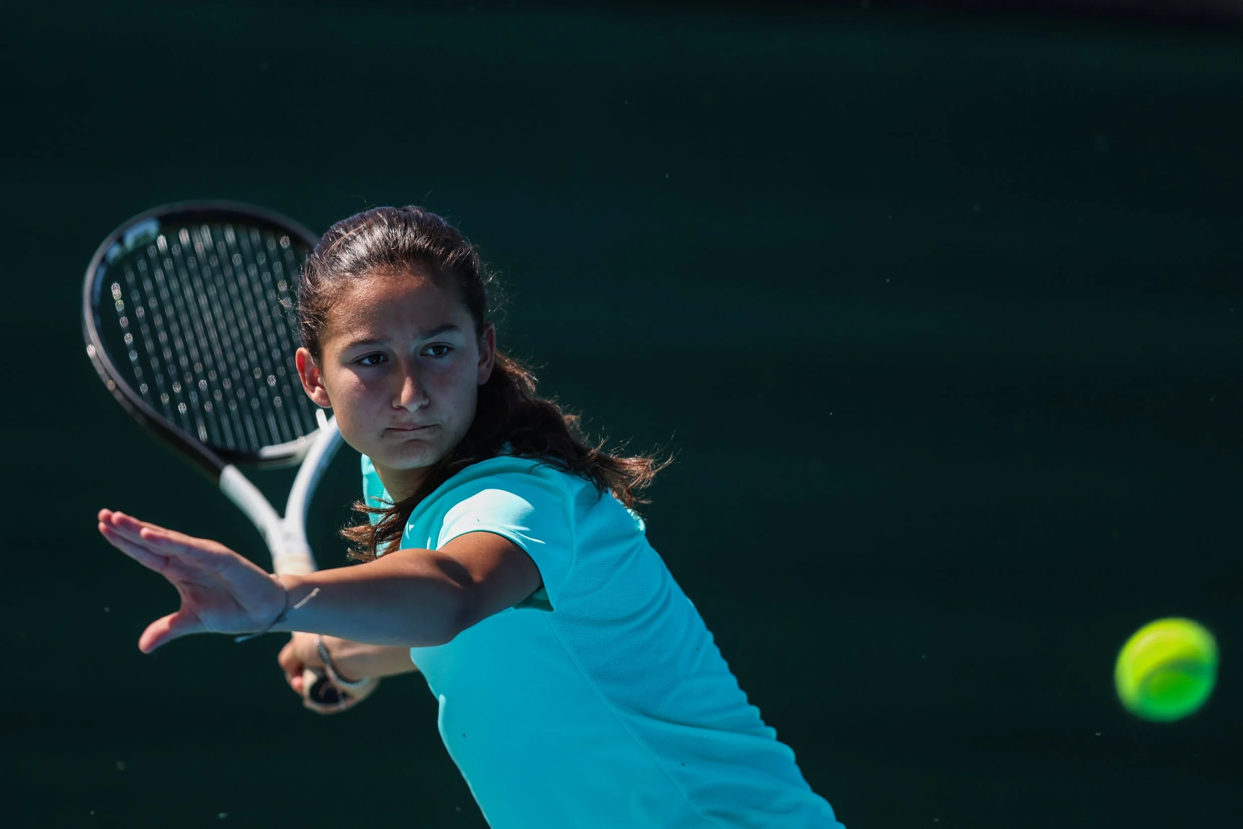 Tennis player on Nike Tennis Camp crouching to return ball