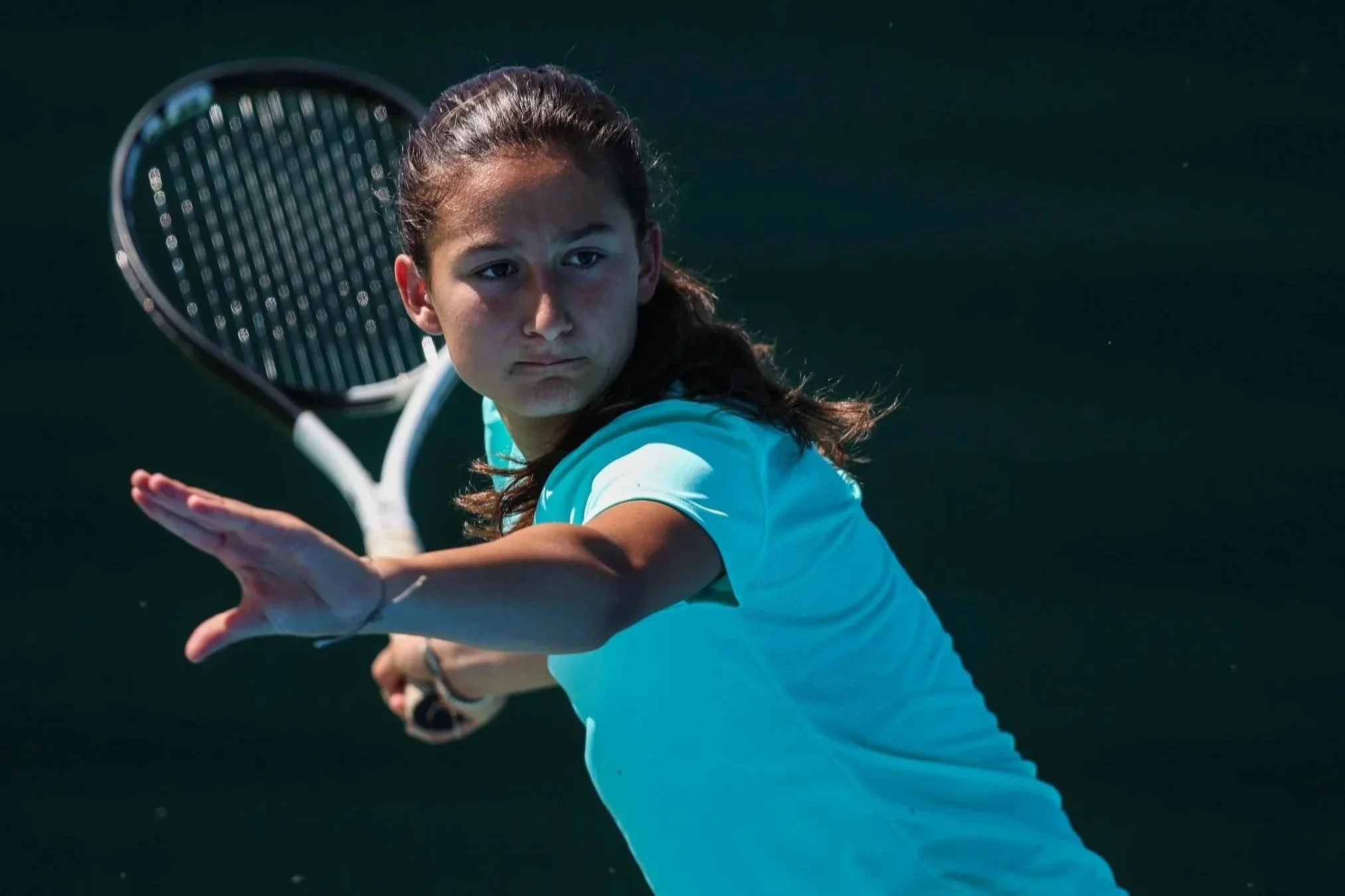 Tennisspieler beim Nike Tennis Camp, der sich duckt, um den Ball zurückzuspielen