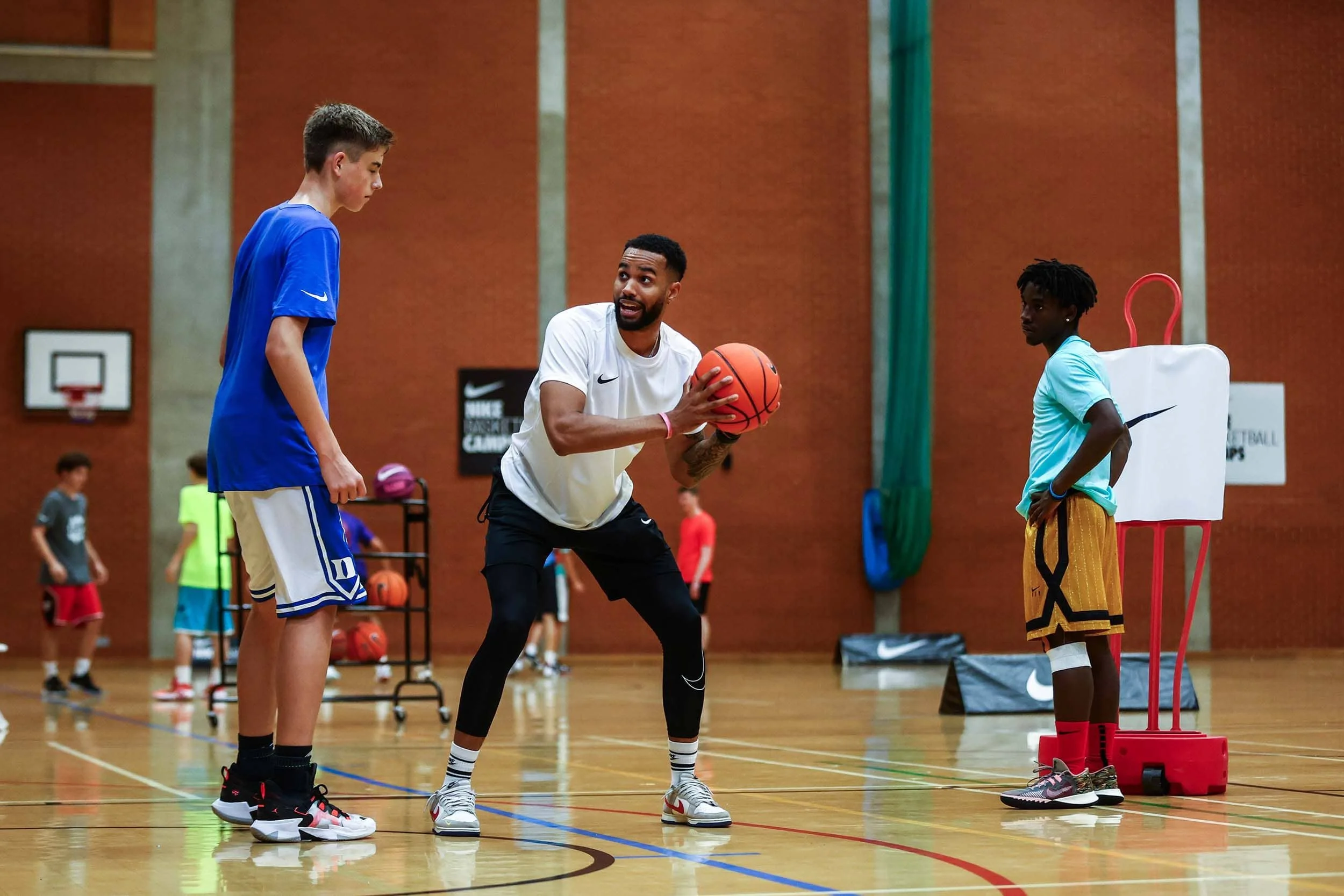 Basketballtrainer hilft Spieler bei einer Übung im Nike Basketball Camp
